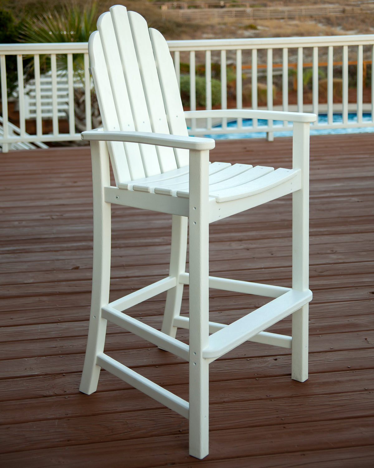 POLYWOOD Classic Adirondack Bar Chair in White in an outdoor setting