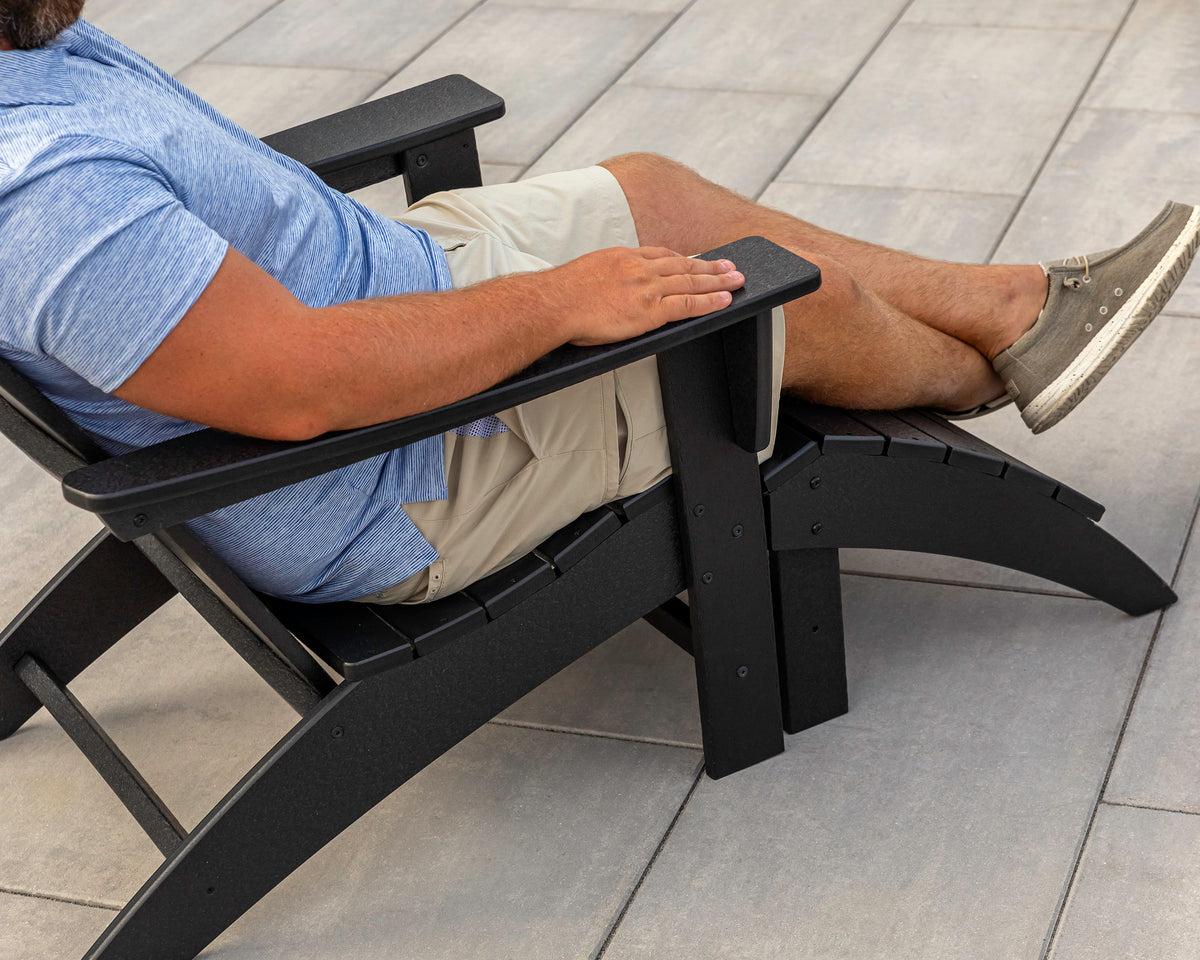 Lifestyle photo of the POLYWOOD Vineyard Adirondack Ottoman in Black