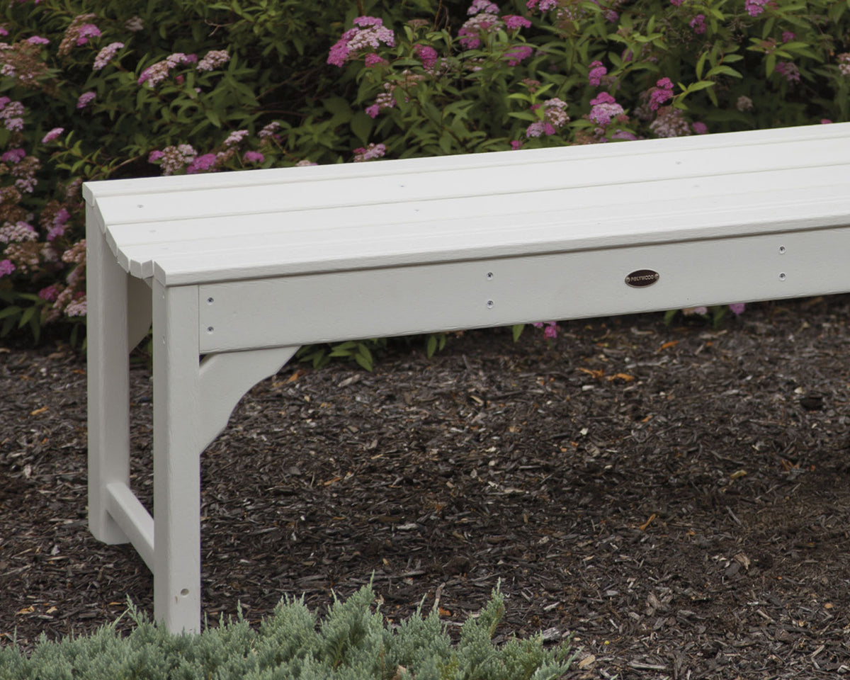 Close-up of the White POLYWOOD Traditional Garden 48" Backless Bench in front of a flowering shrub