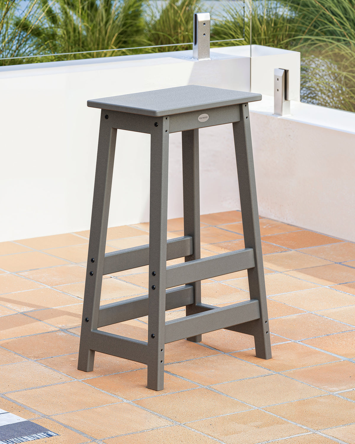 POLYWOOD Modern Studio Bar Stool in Slate Grey in an outdoor setting