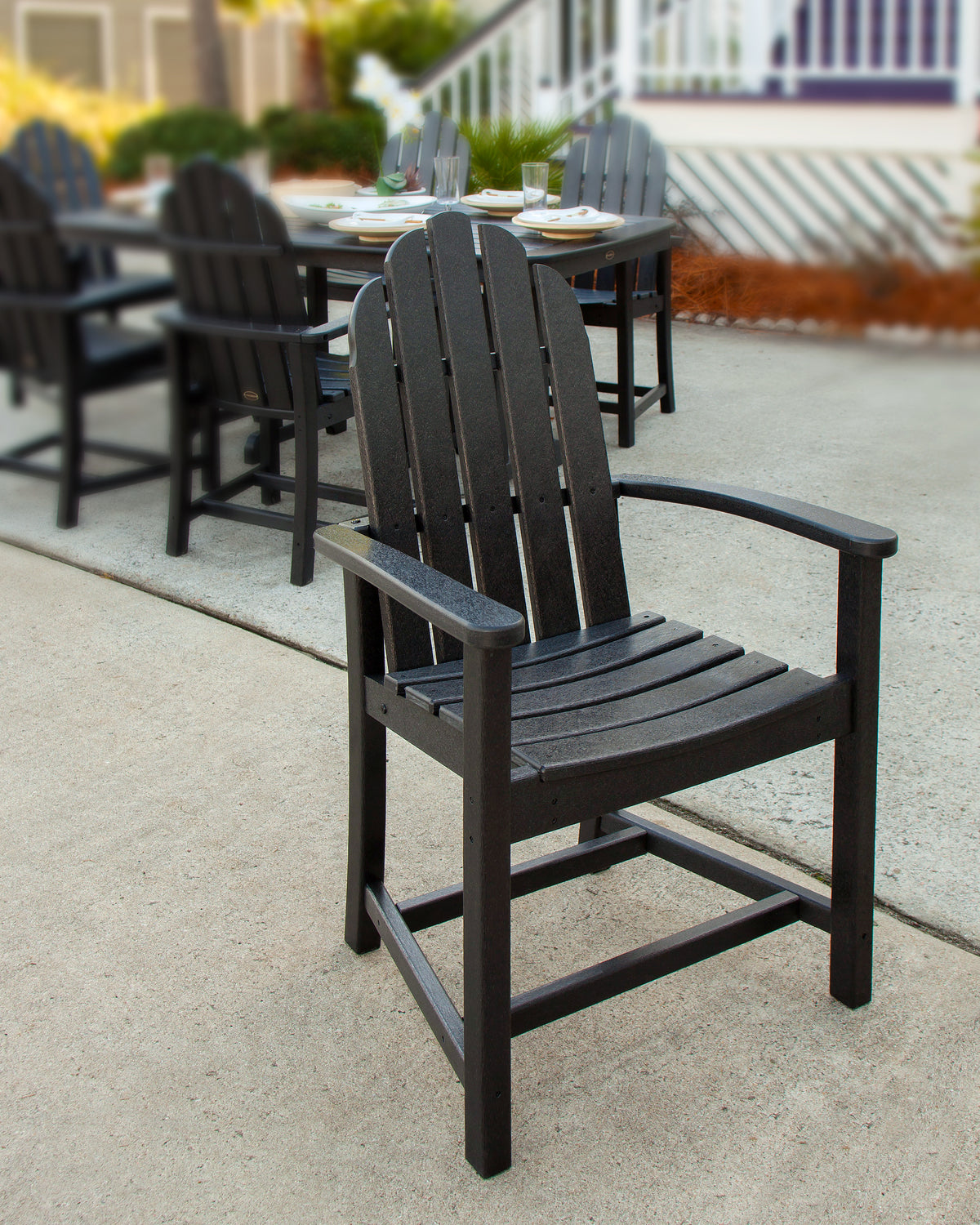 Lifestyle photo of the POLYWOOD Classic Adirondack Dining Chair in Black