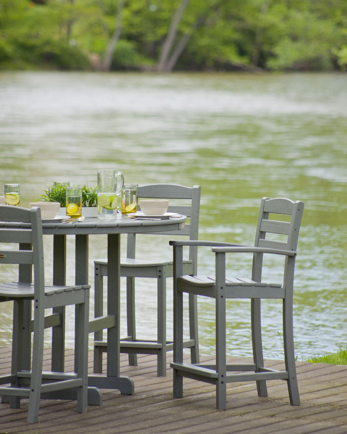 POLYWOOD La Casa Café Counter Arm Chair in Slate Grey in an outdoor setting