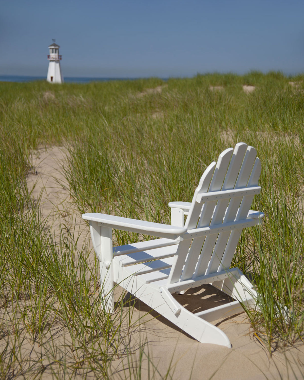 Lifestyle photo of the POLYWOOD Classic Folding Adirondack Chair in White