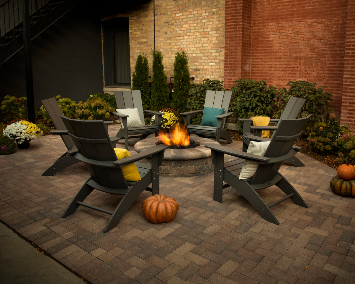 Lifestyle photo of the POLYWOOD Modern Curveback Adirondack Chair in Slate Grey