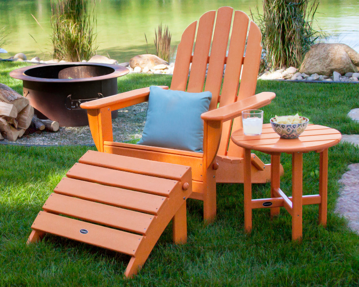 Lifestyle photo of the POLYWOOD Classic Oversized Adirondack Folding Ottoman in Tangerine