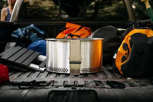 Breeo firepit in the back of a truck with backpacks