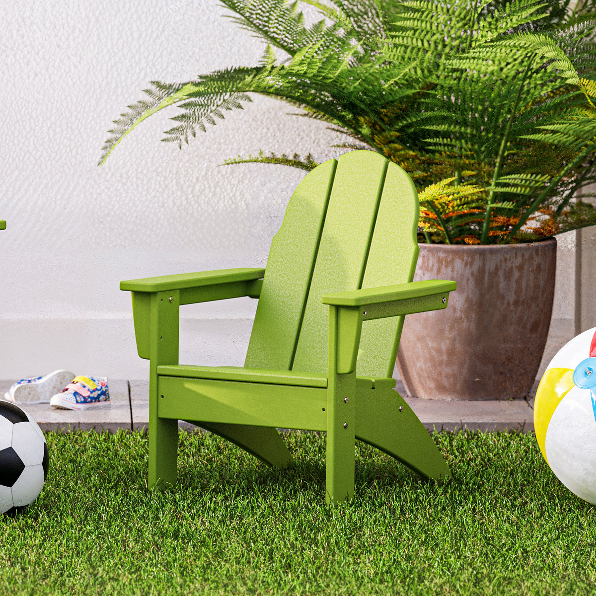 Lifestyle photo of the POLYWOOD Kids Vineyard Adirondack Chair in Lime