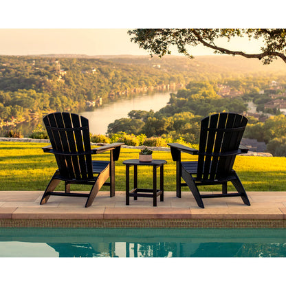 Two black Adirondack chairs with a small table by a pool, overlooking a scenic landscape.