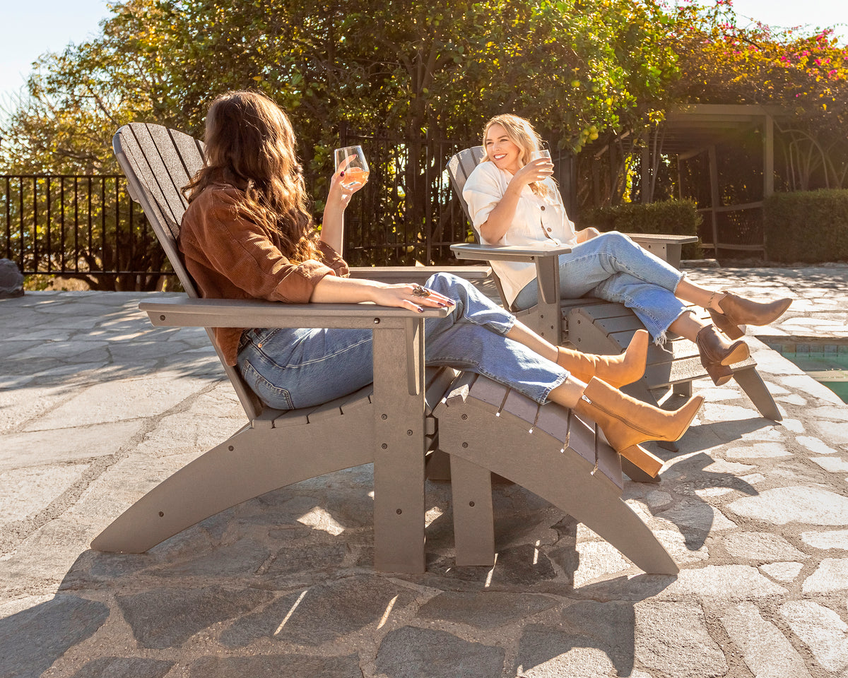 POLYWOOD Vineyard Curveback Adirondack Ottoman in Slate Grey in an outdoor setting