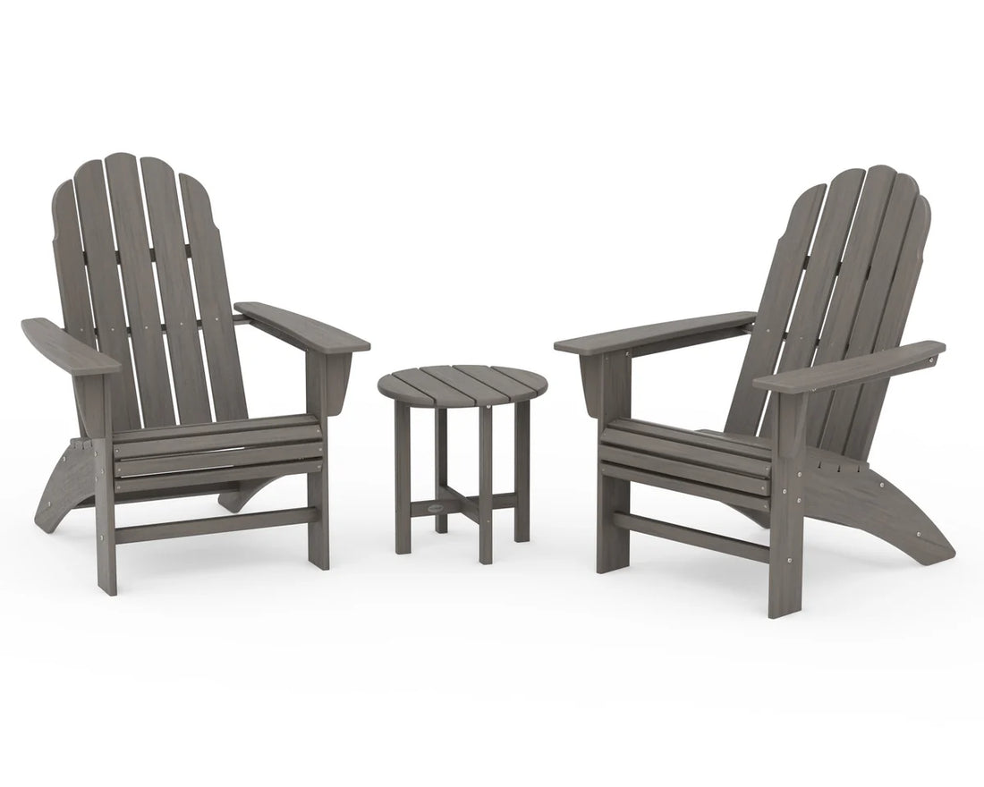 Two gray Adirondack chairs with a matching side table on a white background