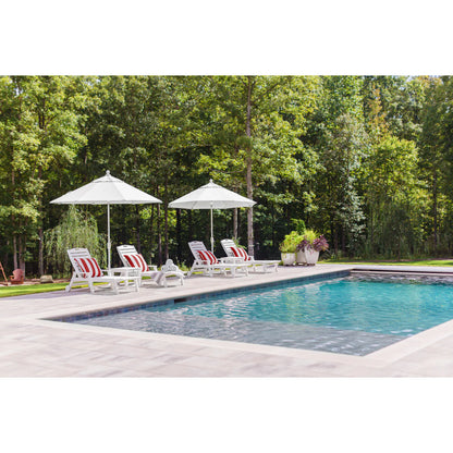 Pool area with lounge chairs and umbrellas surrounded by trees