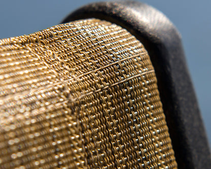 Close-up of the woven tan sling and Black frame of the POLYWOOD Coastal Folding Chair