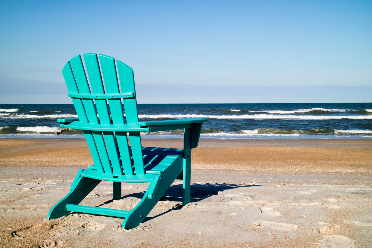 Lifestyle photo of the POLYWOOD Palm Coast Folding Adirondack in Aruba