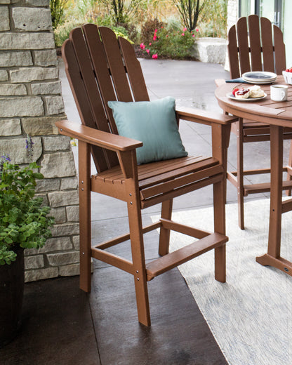 POLYWOOD Vineyard Curveback Adirondack Bar Chair in Teak in an outdoor setting