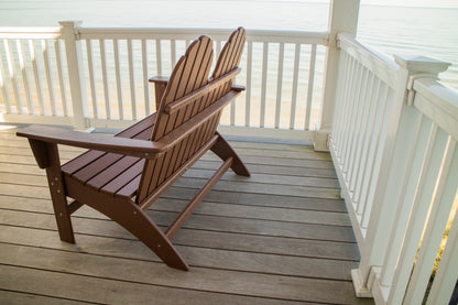 Side angle of the Teak POLYWOOD Vineyard 48" Adirondack Bench showing its reclined back on a porch