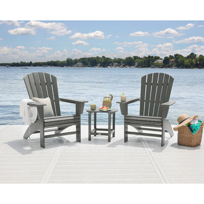 Two gray Adirondack chairs with a small table on a dock by a lake.