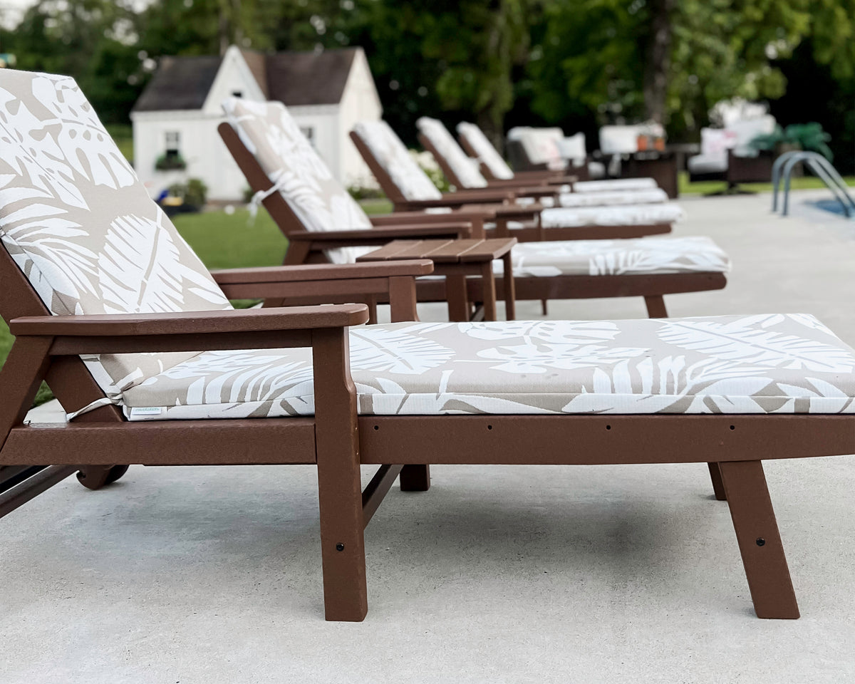 Lifestyle photo of the POLYWOOD Vineyard Chaise with Arms and Wheels in Teak