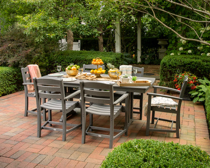 Lifestyle photo of the POLYWOOD La Casa Café 7-Piece Arm Chair Dining Set with Trestle Legs