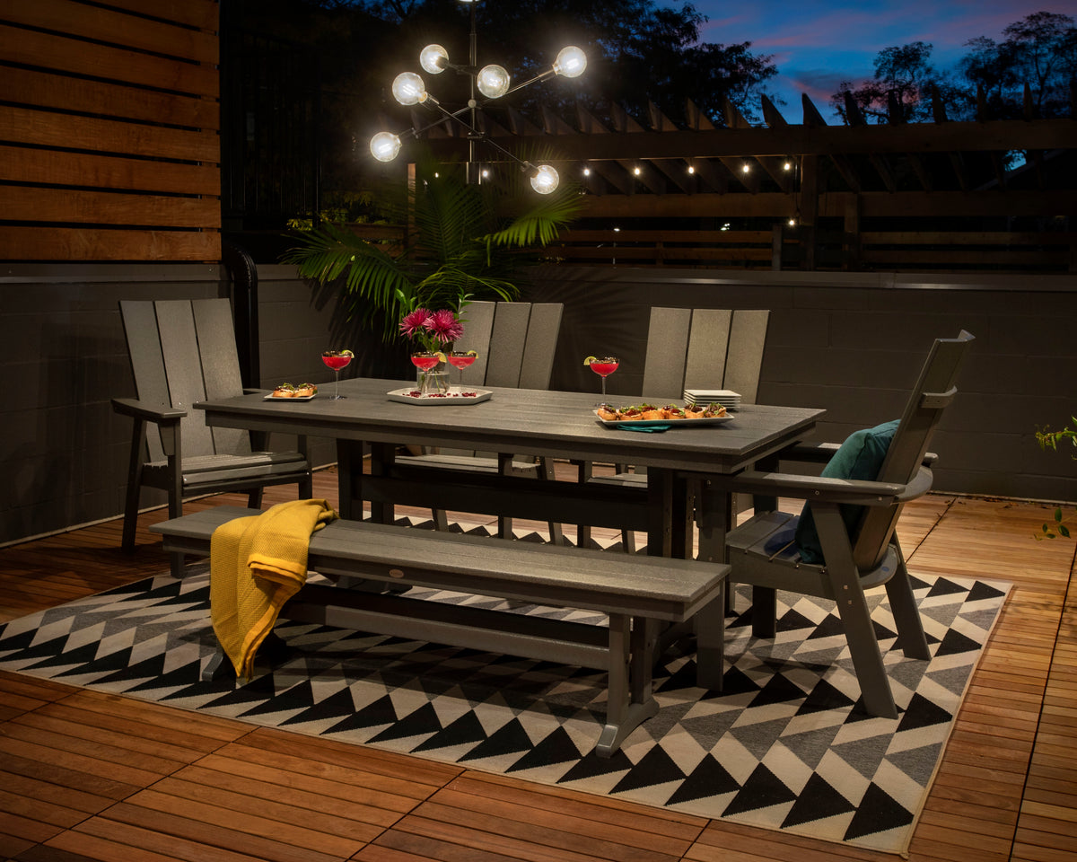 Lifestyle photo of the POLYWOOD Modern Curveback Adirondack 6-Piece Farmhouse Dining Set with Trestle Legs and Bench - 37" x 72" Table