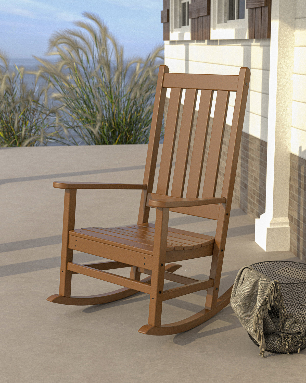 Lifestyle photo of the POLYWOOD Vineyard Porch Rocking Chair in Teak