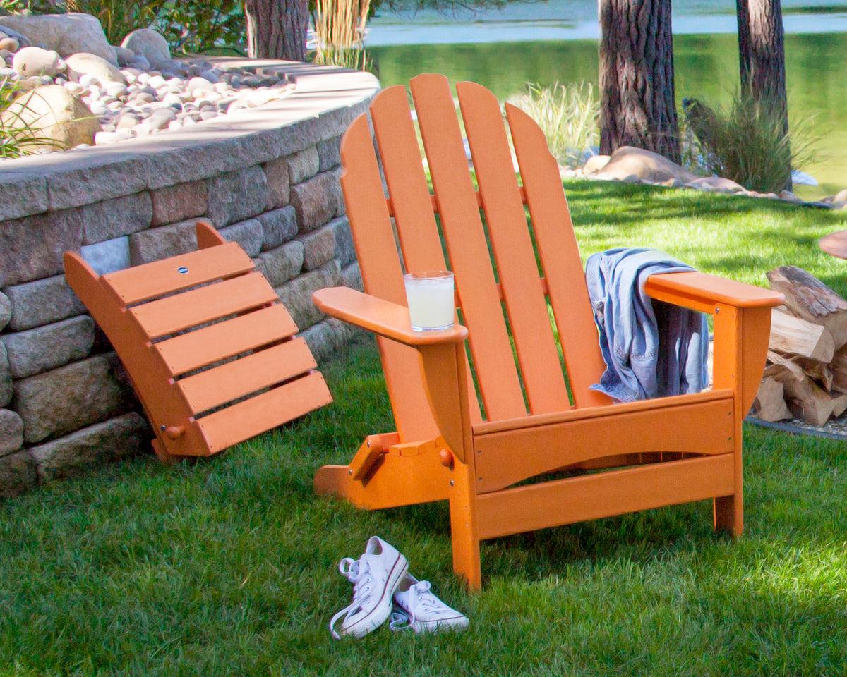 POLYWOOD Classic Oversized Adirondack Folding Ottoman in Tangerine in an outdoor setting