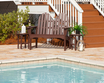 Mahogany POLYWOOD Classic Adirondack 48" Bench on a pool deck between two side tables