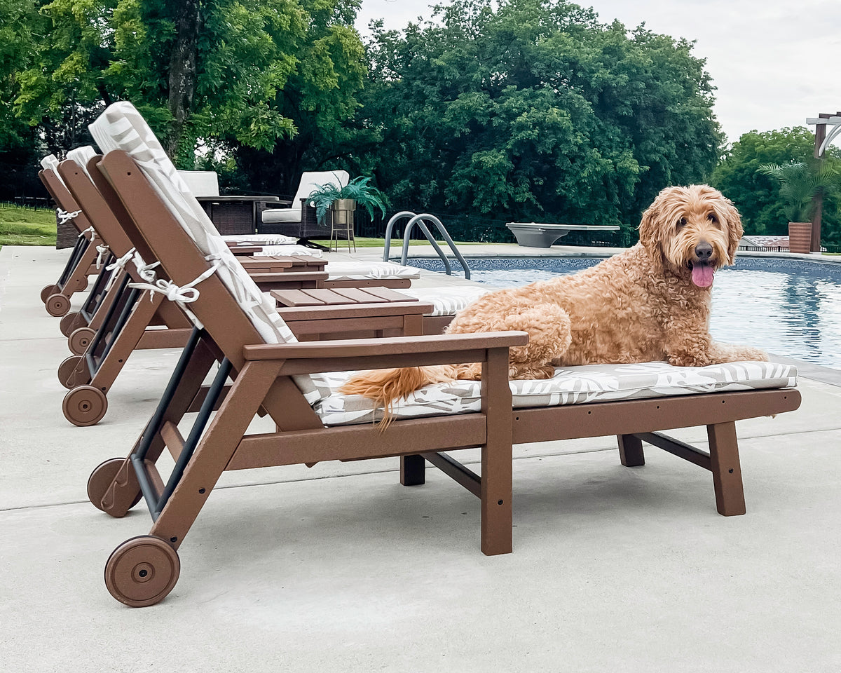 Lifestyle photo of the POLYWOOD Vineyard Chaise with Arms and Wheels in Teak (2)