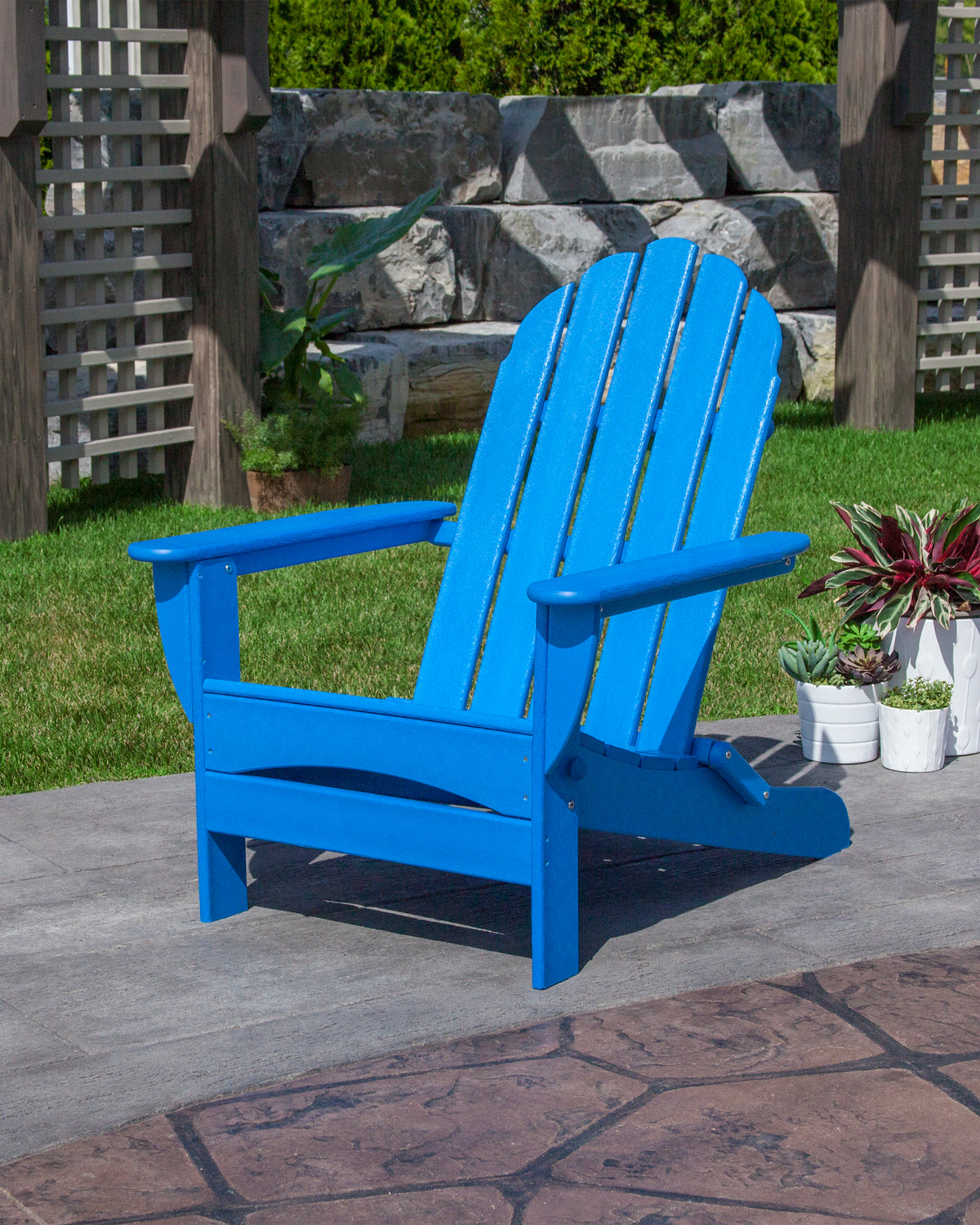 Lifestyle photo of the POLYWOOD Classic Oversized Folding Adirondack Chair in Pacific Blue